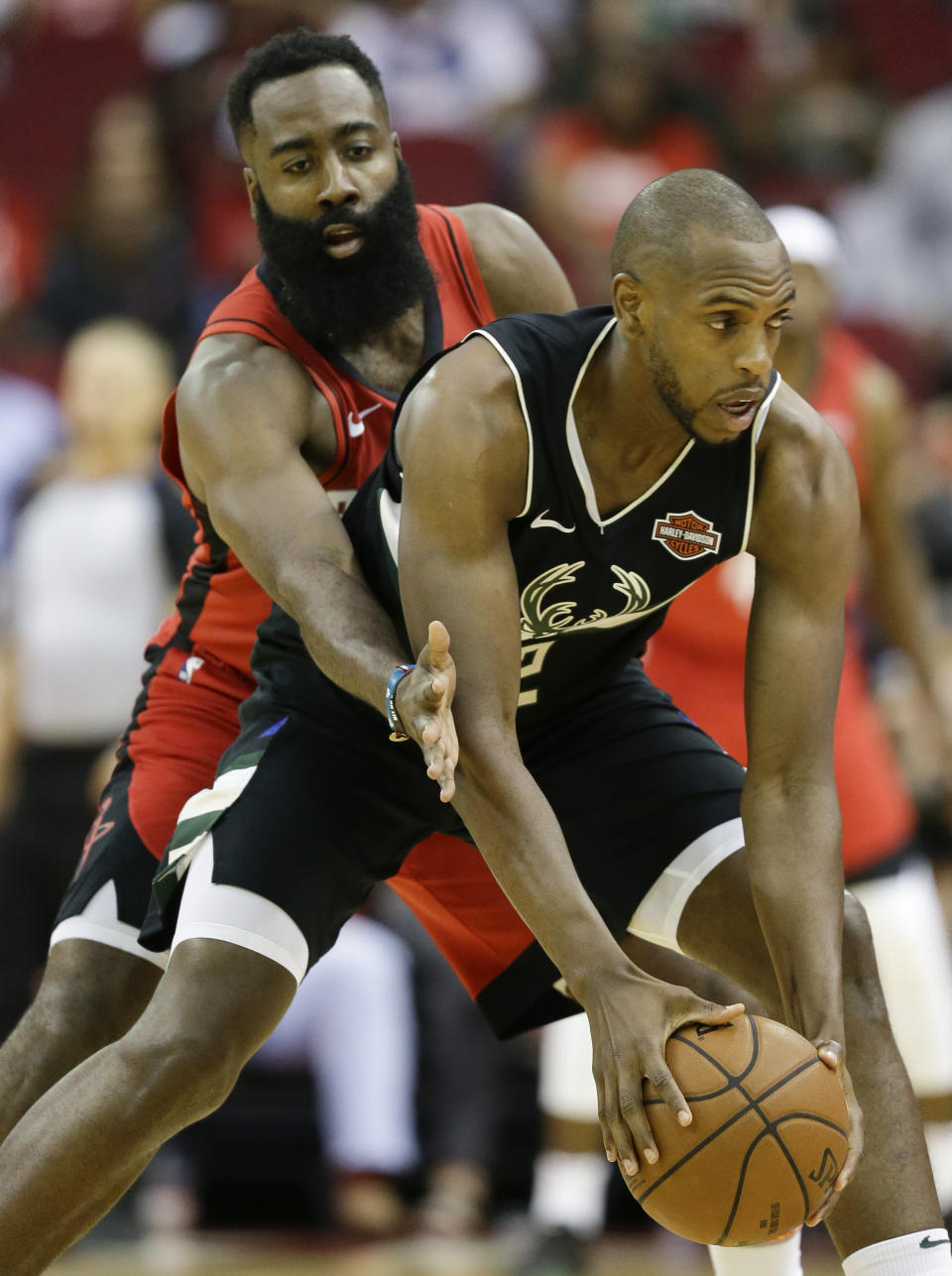 Milwaukee Bucks forward Khris Middleton, right, looks to pass as Houston Rockets guard James Harden defends during the first half of an NBA basketball game Thursday, Oct. 24, 2019, in Houston. (AP Photo/Eric Christian Smith)