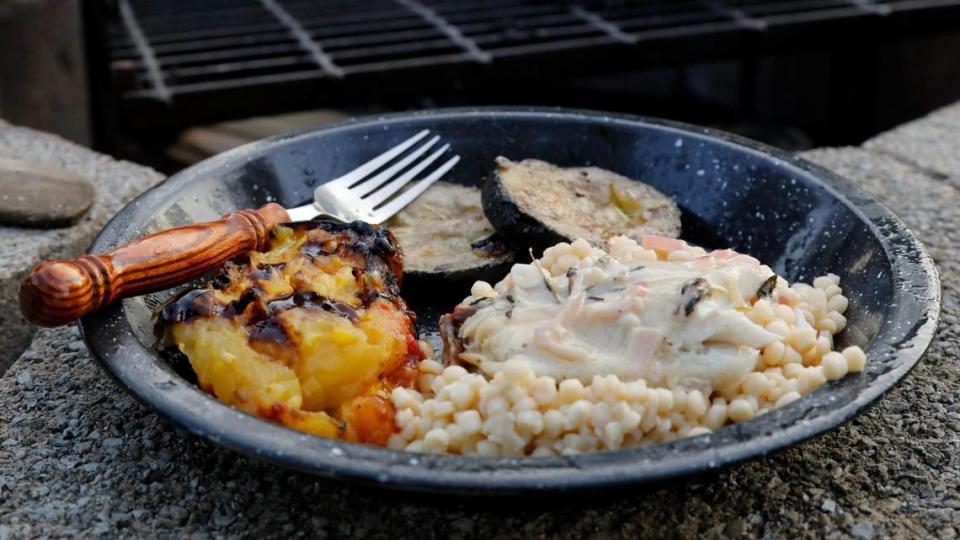 Pan seared and buttered tilapia with a white wine cream sauce and shallots served on pearl couscous alongside grilled cucumber and tomato on Tuesday, July 25, 2023 at Bourbon Barrel Cottages in Lawrenceburg, Ky.