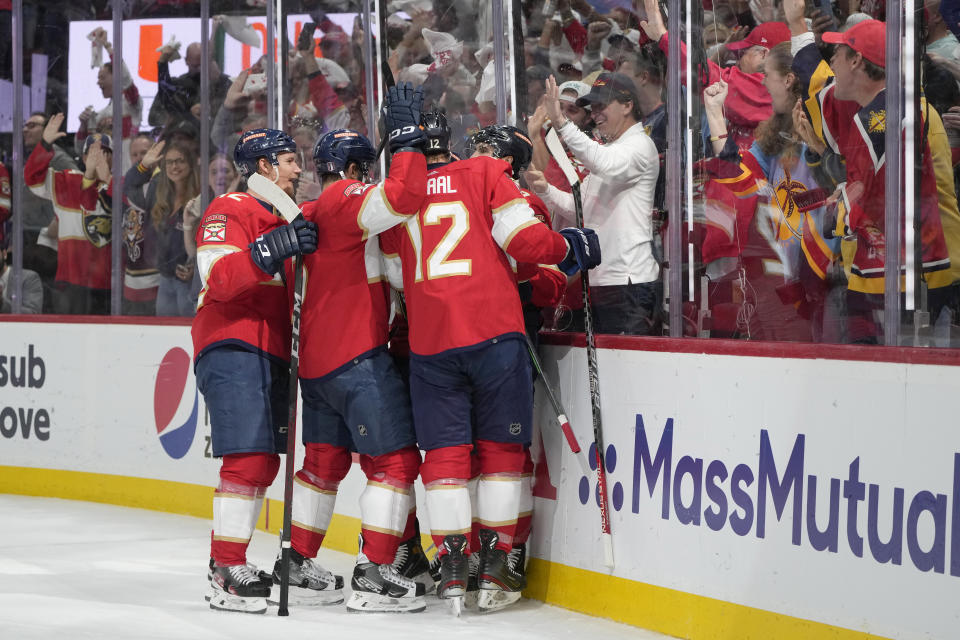 Teammates mob Florida Panthers left wing Ryan Lomberg after he scored during the second period of Game 4 of the NHL hockey Stanley Cup Eastern Conference finals against the Carolina Hurricanes, Wednesday, May 24, 2023, in Sunrise, Fla. (AP Photo/Wilfredo Lee)