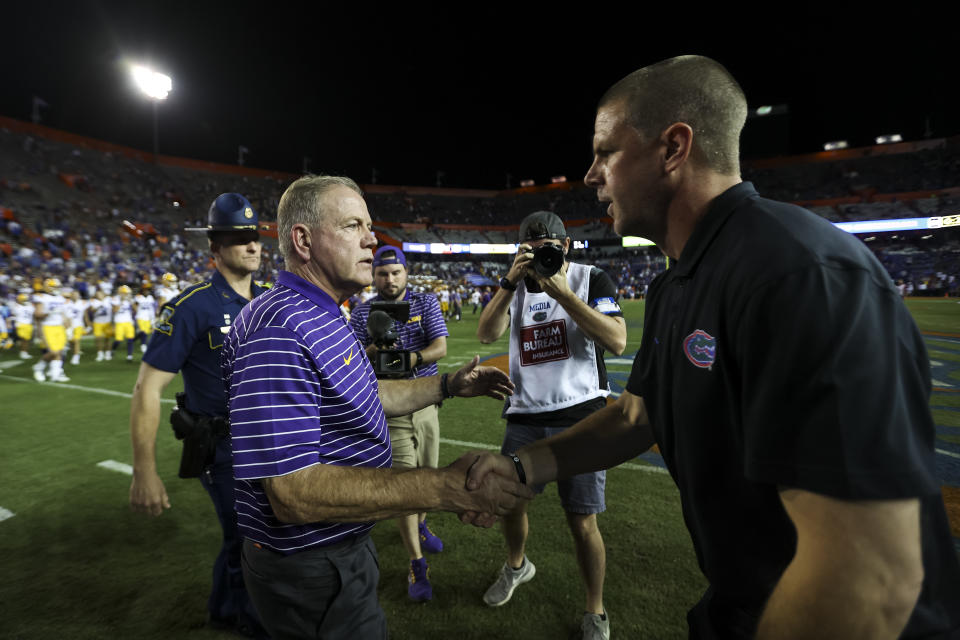 GAINESVILLE, FLORIDA - OCTOBER 15: head coach Brian Kelly of the LSU Tigers (L) shakes hands with head coach Billy Napier of the Florida Gators (R) after a game at Ben Hill Griffin Stadium on October 15, 2022 in Gainesville, Florida. (Photo by James Gilbert/Getty Images)