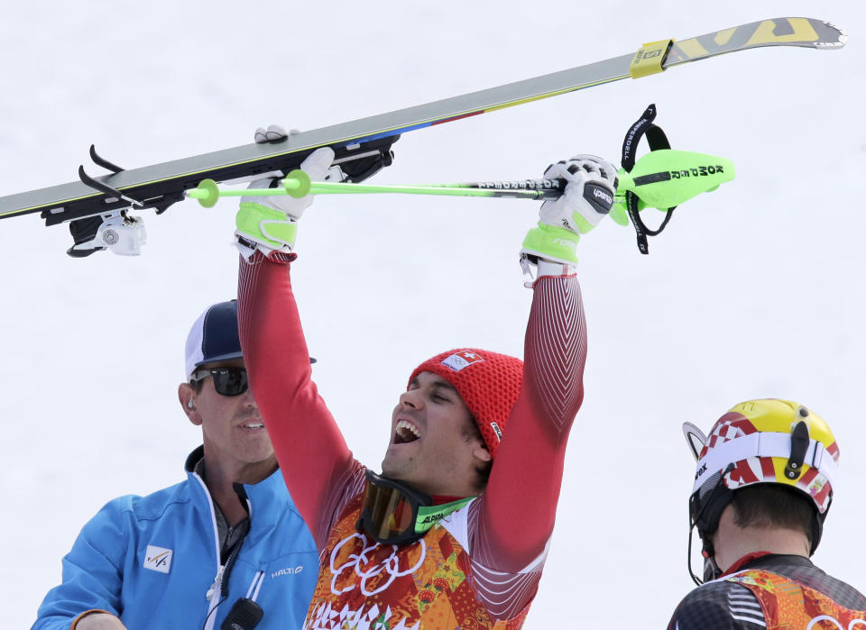 Switzerland's Sandro Viletta celebrates winning the gold medal in the men's supercombined as silver medalist Croatia's Ivica Kostelic, right, stands next to him at the Sochi 2014 Winter Olympics, Friday, Feb. 14, 2014, in Krasnaya Polyana, Russia. (AP Photo/Gero Breloer)