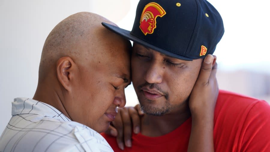 JP Mayoga (right), a chef at the Westin Maui, Kaanapali, and his wife, Makalea Ahhee, hug on their balcony at the hotel and resort Sunday near Lahaina, Hawaii. About 200 employees are living there with their families. Officials urge tourists to avoid traveling to Maui as many hotels prepare to house evacuees and first responders on the island where a wildfire demolished a historic town and killed dozens of people. (Photo: Rick Bowmer/AP)