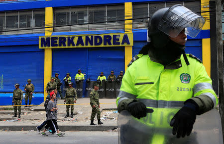 Colombian police and soldiers guard a supermarket supposedly linked to FARC in Bogota, Colombia February 21, 2018. REUTERS/Jaime Saldarriaga