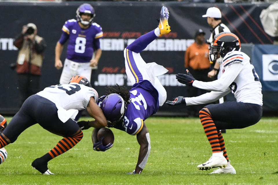 Minnesota Vikings running back Dalvin Cook, center, is upended after catching a pass as Chicago Bears cornerback Kyle Fuller, left, and defensive back Deon Bush, right, defend during the half of an NFL football game Sunday, Sept. 29, 2019, in Chicago. (AP Photo/Matt Marton)