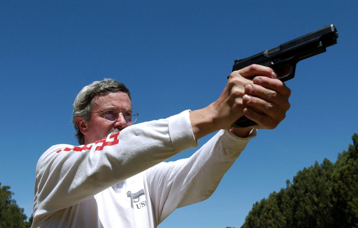 Image: Bruce Gray, a professional shooter, demonstrates how to hold a handgun during a National Shooting Sports Foundation event in 2002. (Justin Sullivan / Getty Images file)