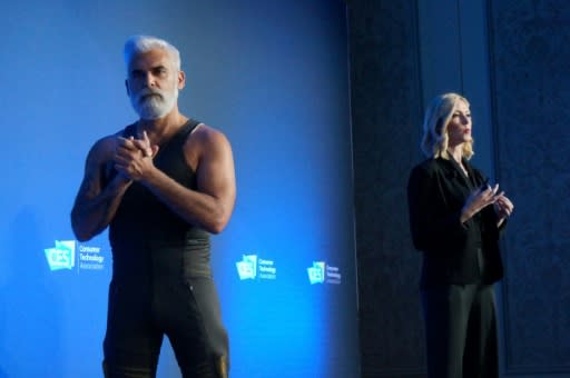 Sarah Thomas (R) of California startup Seismic talks to the 2019 Consumer Electronics Show about "powered clothing" using robotic muscles to help people with fatigue and disabilities, as customer Bob Copani of San Francisco models the garment