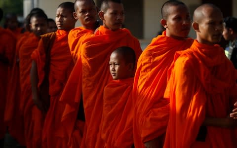 Cambodian Buddhist monks wait in queue to enter into the courtroom - Credit:  Heng Sinith/AP