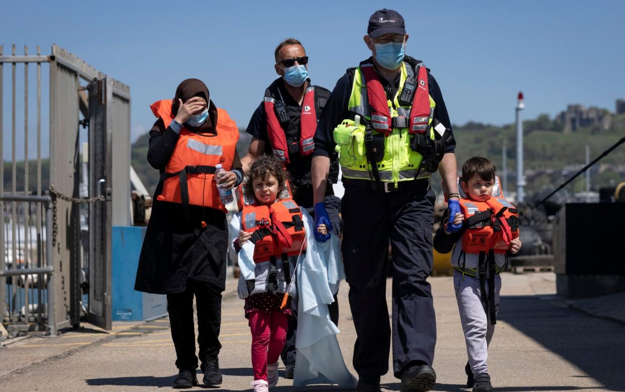 Border Force officials guide newly arrived migrants, including children, to a holding facility after being picked up in a dinghy in the English Channel - Dan Kitwood 