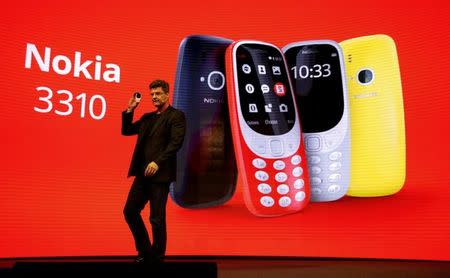 Arto Nummela, CEO of Nokia-HMD, holds up Nokia 3310 device during presentation ceremony at Mobile World Congress in Barcelona, Spain, February 26, 2017. REUTERS/Paul Hanna