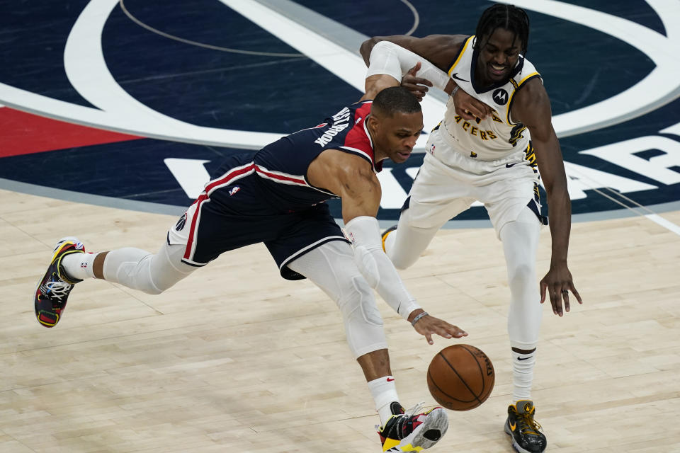 Washington Wizards guard Russell Westbrook (4) gets past Indiana Pacers guard Justin Holiday (8) during the second half of a basketball game, Monday, May 3, 2021, in Washington. (AP Photo/Alex Brandon)