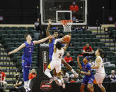 Kansas guard Christian Braun, left, and forward K.J. Adams, center top, defend against Iona guard Elijah Joiner, center bottom, during the second half of an NCAA college basketball game Sunday, Nov. 28, 2021, in Lake Buena Vista, Fla. (AP Photo/Jacob M. Langston)