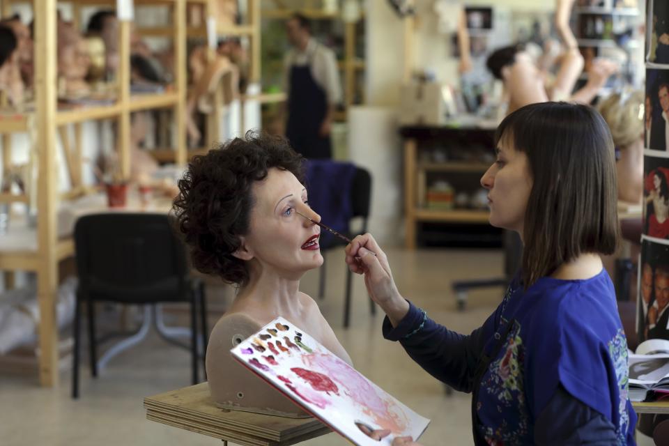 Helene Jonca, one of the painters at the Paris Grevin Wax Museum works on the head of late French singer Edith Piaf at the museum's workshop in Paris