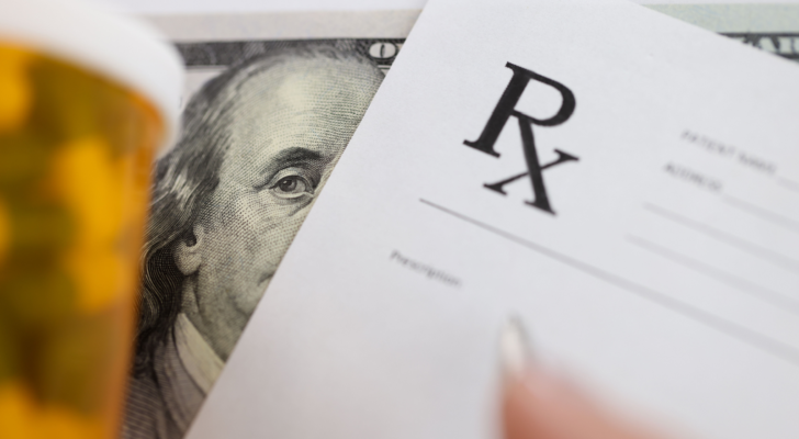 Dollar bill and doctors prescription are on doctors table in clinic closeup. Drug corruption and fraud.