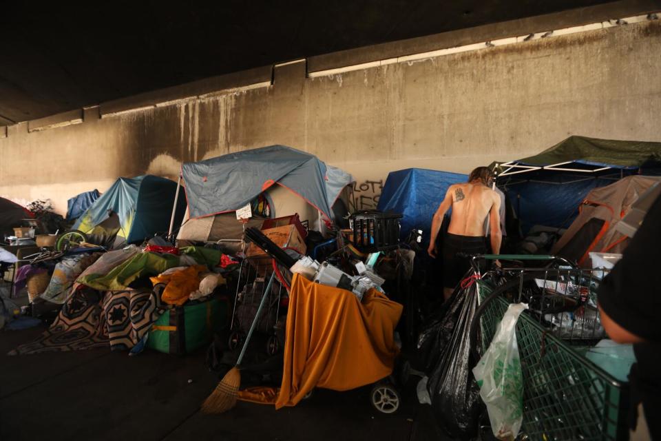 A shirtless man is seen at a homeless encampment under the 134 freeway in North Hollywood in July 2020.