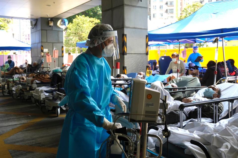 Patients in hospital beds wait in a temporary holding area outside Caritas Medical Centre in Hong Kong (AP)