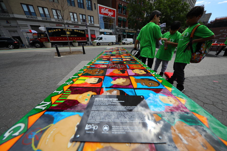 <p>Students stand next to the “Being accepted” table for the LEAP Public Art Program’s citywide exhibition in Union Square Park in New York City on June 5, 2018. (Photo: Gordon Donovan/Yahoo News) </p>