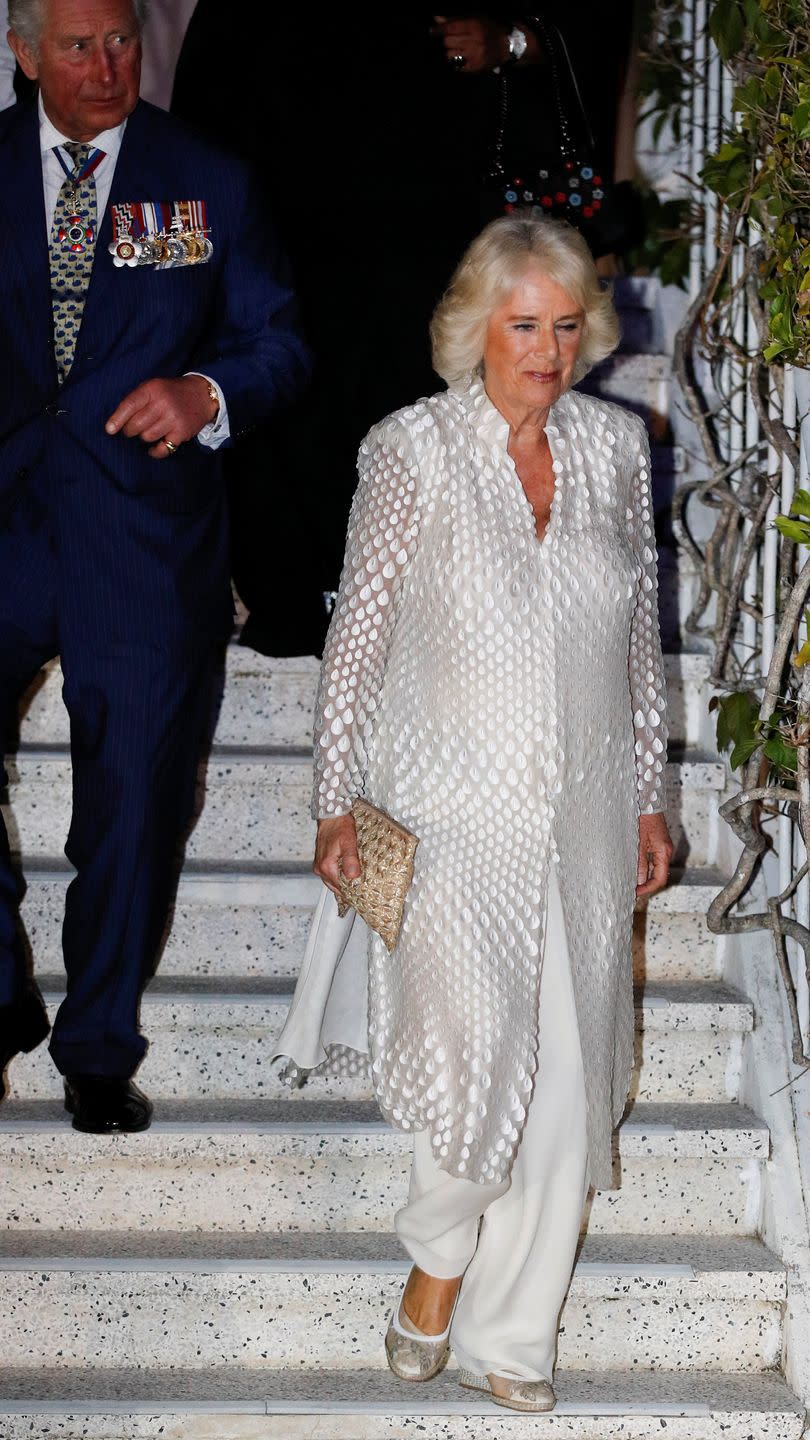 <p>On the first night of <a href="https://www.townandcountrymag.com/society/tradition/g26850147/prince-charles-camilla-parker-bowles-royal-tour-caribbean-2019-photos/" rel="nofollow noopener" target="_blank" data-ylk="slk:Camilla and Charles's Caribbean tour;elm:context_link;itc:0;sec:content-canvas" class="link ">Camilla and Charles's Caribbean tour</a>, the Duchess paired a white sheer caftan with appliqué detailing, white wide-legged dress pants, and a wicker clutch for a dinner at Prime Minister's residence in Barbados. </p>