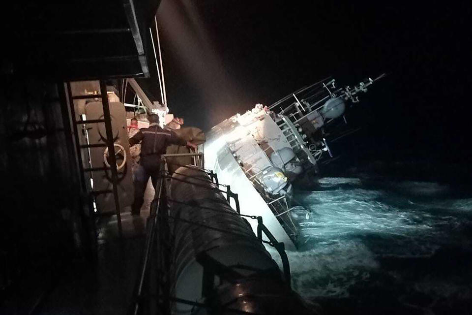 In this photo provided by the Royal Thai Navy, the HTMS Sukhothai corvette warship lists off the coast of Prachuap Khiri Khan province, Thailand, Sunday, Dec. 18, 2022. The Thai navy ship sunk in the Gulf of Thailand and ships and helicopters were working Monday to rescue sailors from the water. (Royal Thai Navy via AP)