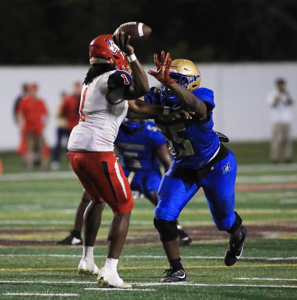 Mainland’s Christian Hudson runs towards the quarterback and blocks the ball during Friday night’s game against Vanguard.