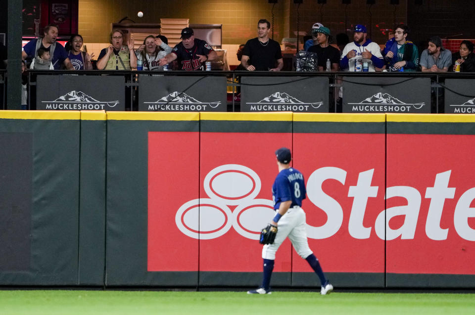 Seattle Mariners left fielder AJ Pollock (8) watches a home run by Minnesota Twins' Carlos Correa fly into the bullpen during the ninth inning of a baseball game Tuesday, July 18, 2023, in Seattle. (AP Photo/Lindsey Wasson)