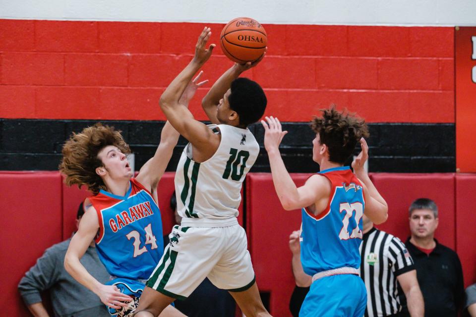 Malvern's J'Allen Barrino puts up two points as Garway's Jenson Garber attempts to block during the Division III District Championship Game, Friday, Mar. 3 at New Philadelphia High School.