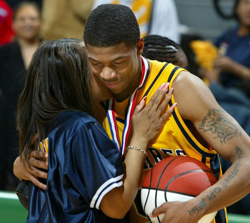 Detroit St. Martin dePorres' Brandon Cotton, right, gets a hug from his mother, Monica Smith, after defeating Flint Beecher 62-46 to win the 2003 Class C state championship.