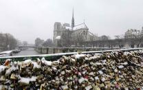 �Snow covers some of thousands of padlocks clipped by lovers onto the railings of Pont de l'Arceveche bridge along the River Seine near Notre Dame Cathedral in Paris.