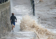 Early morning runners in Clevedon, Somerset, were forced to dodge and jump the waves crashing into the seafront on Sunday as Storm Alex continued to batter Britain. (SWNS)