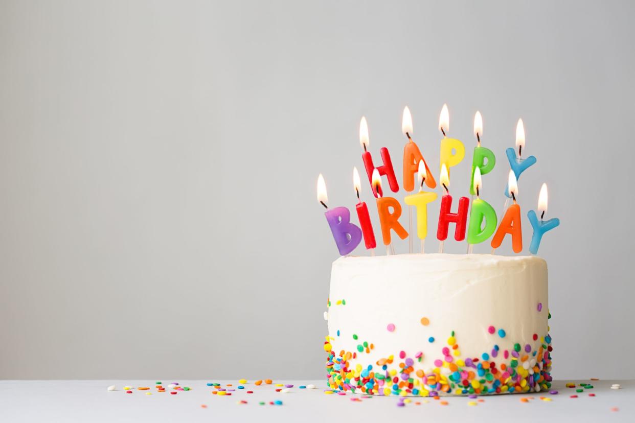 Birthday cake with colorful candles spelling happy birthday