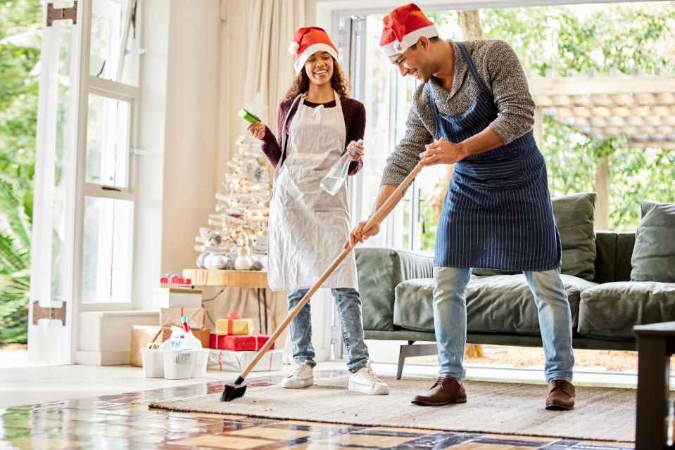 Shot of a young couple cleaning the lounge at home