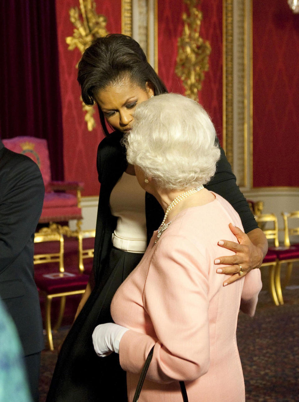 Michelle Obama puts her arm around the Queen at a reception at Buckingham Palace, London, 2009. (PA Images)