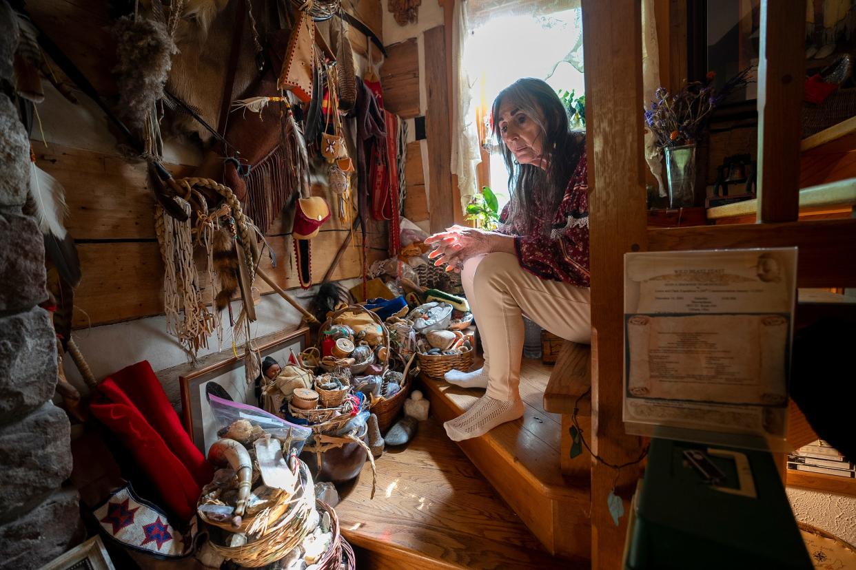 Dark Rain Thom sits near a stairway in her home that holds a collection of traditional Native American items. Dark Rain said she is a Native American, descended from the Shawnee, who tried to help get recognition for the United Remnant Band of Shawnee, which is based in Ohio. The tribe is unrecognized federally but successfully sought some validation from the state legislature in Ohio.