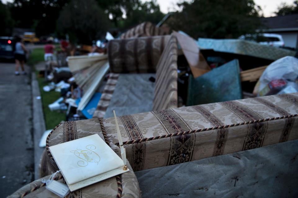 Furniture&nbsp;that was&nbsp;destroyed in the flood&nbsp;is piled&nbsp;on the side of the street.