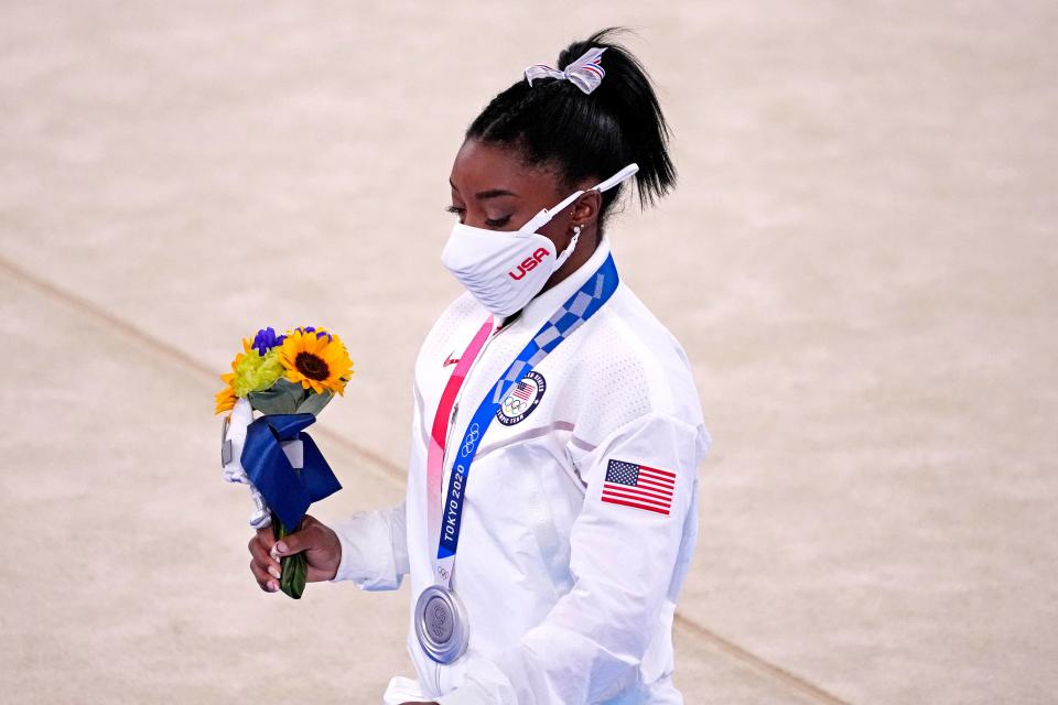 Simone Biles walks off the floor after winning the silver medal in the women's team gymnastics final.