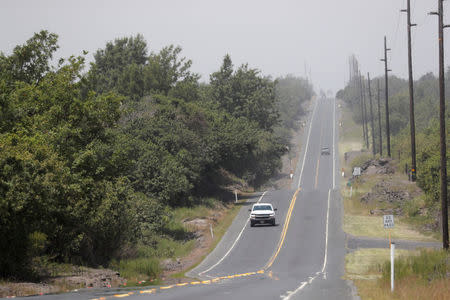 Ash from the Halemaumau crater falls over Highway 11 during the eruption of the Kilauea Volcano near Volcano, Hawaii, U.S., May 23, 2018. REUTERS/Marco Garcia