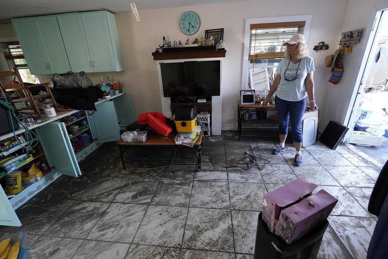 Cindy Bickford looks over her home damaged in Hurricane Ian, Thursday, Oct. 6, 2022, in Pine Island, Fla.