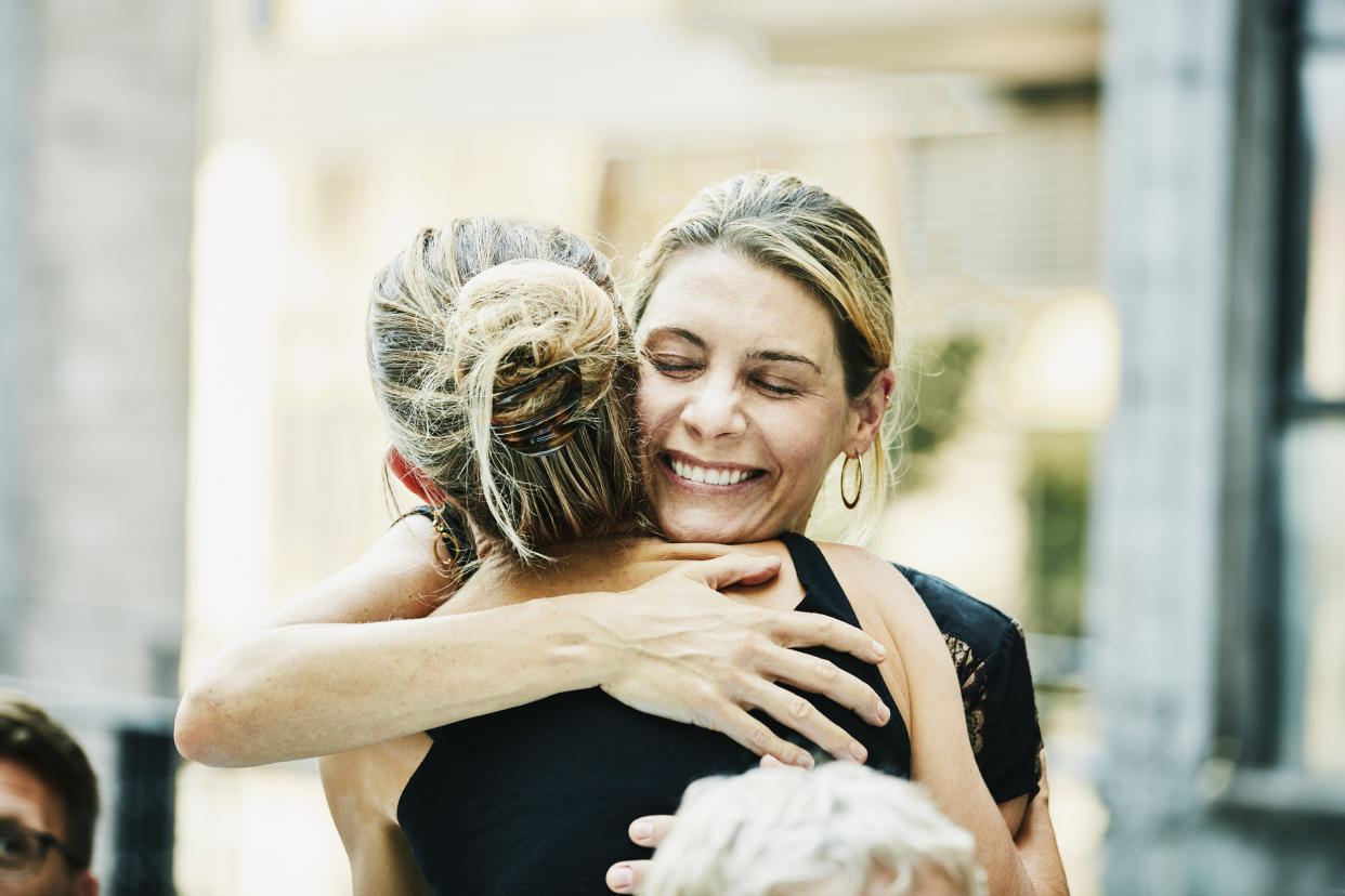 Two women embrace