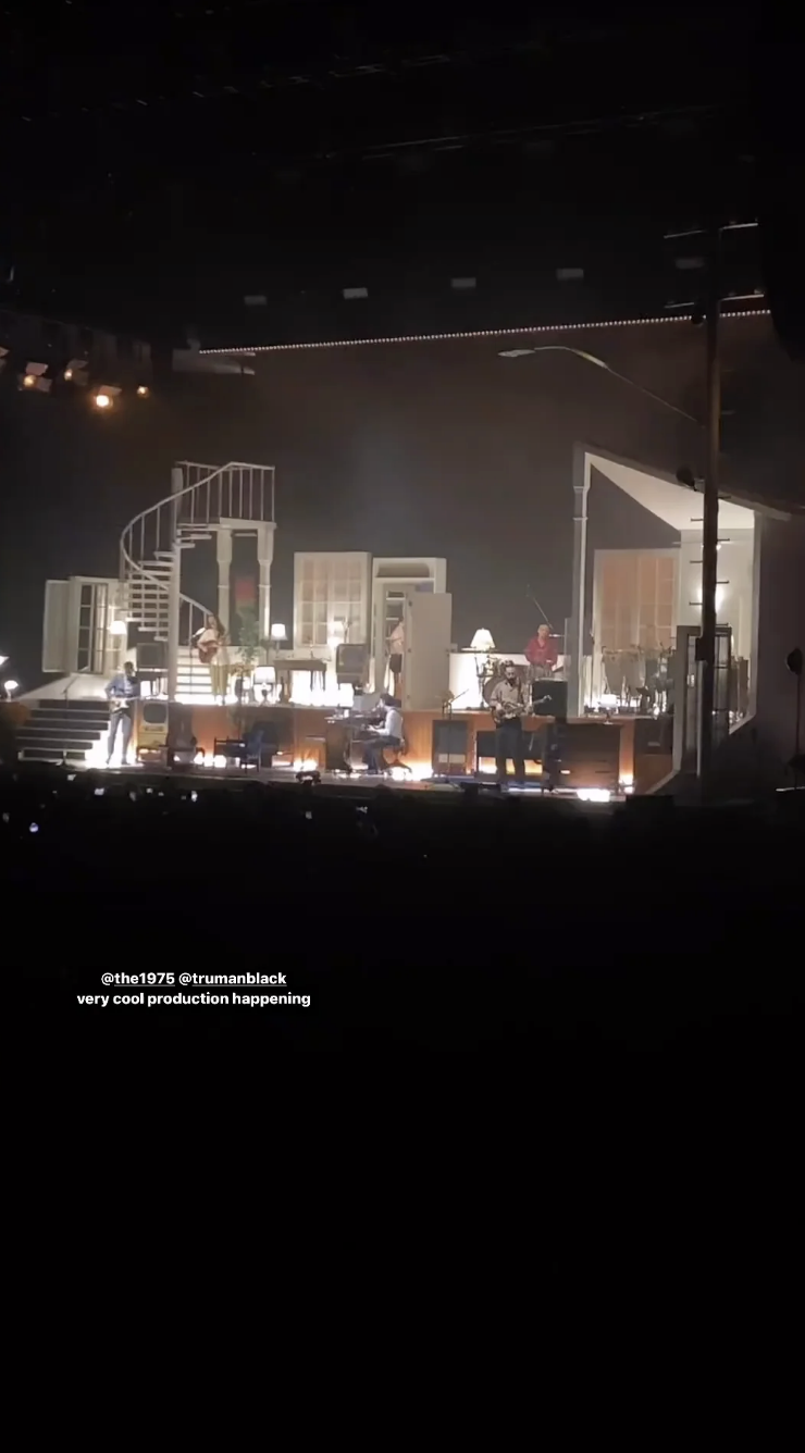 Band The 1975 performing on stage with a house-like set design, captioned with a fan noting cool production