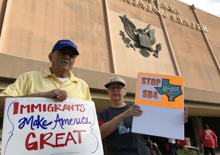 Protesters against the Texas state law to punish "sanctuary cities" stands outside the U.S. Federal court in San Antonio, Texas, U.S., June 26, 2017. REUTERS/Jon Herskovitz