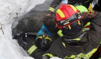 Picture released by Italy's Vigili del Fuoco fire service shows a child (C) being rescued from the Hotel Rigopiano, in the mountains of central Italy, on January 20, 2017 after they were buried under an avalanche