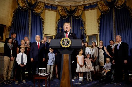 FILE PHOTO: U.S. President Donald Trump calls on Republican Senators to move forward and vote on a healthcare bill to replace the Affordable Care Act, as people negatively affected by the law stand behind him, in the Blue Room of the White House in Washington, U.S., July 24, 2017. REUTERS/Joshua Roberts