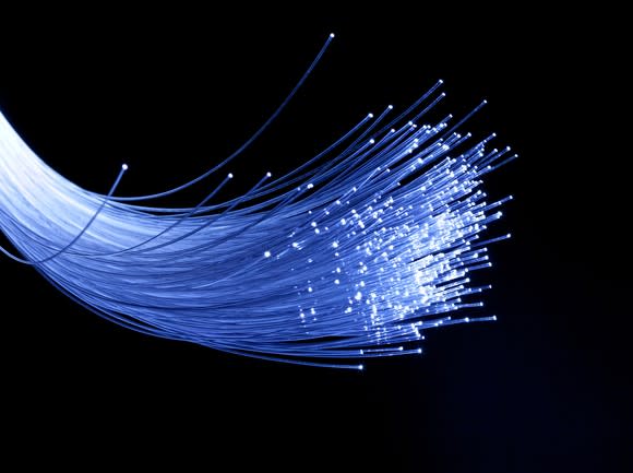 A bundle of lit fiber-optic wires against a black backdrop.