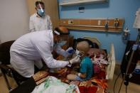 A nurse helps a child who suffers from cancer to wear a protective mask at the Children's Hospital for Cancer Diseases in Basra