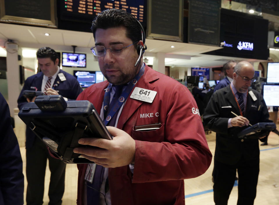 Michael Capolino, center, works with fellow traders on the floor of the New York Stock Exchange Wednesday, Jan. 8, 2014. Stocks are mostly lower in early trading as investors hold back ahead of the release of the latest news from the Federal Reserve. (AP Photo/Richard Drew)
