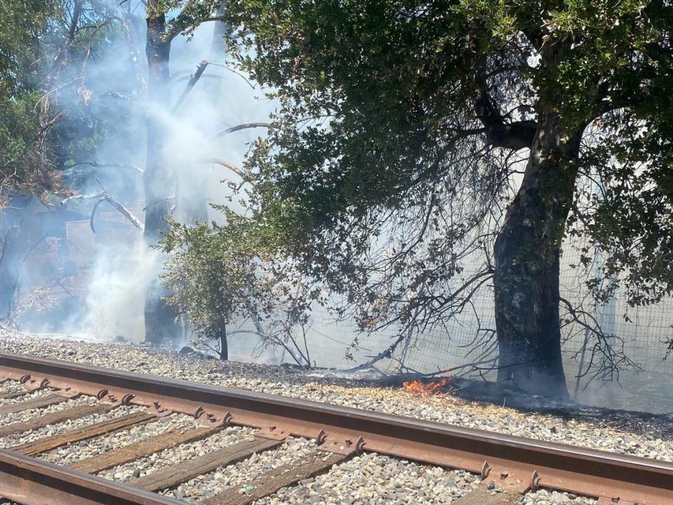 A fire burns a structure near the railroad tracks along Miramon Avenue in Atascadero on Saturday, June 25, 2022.