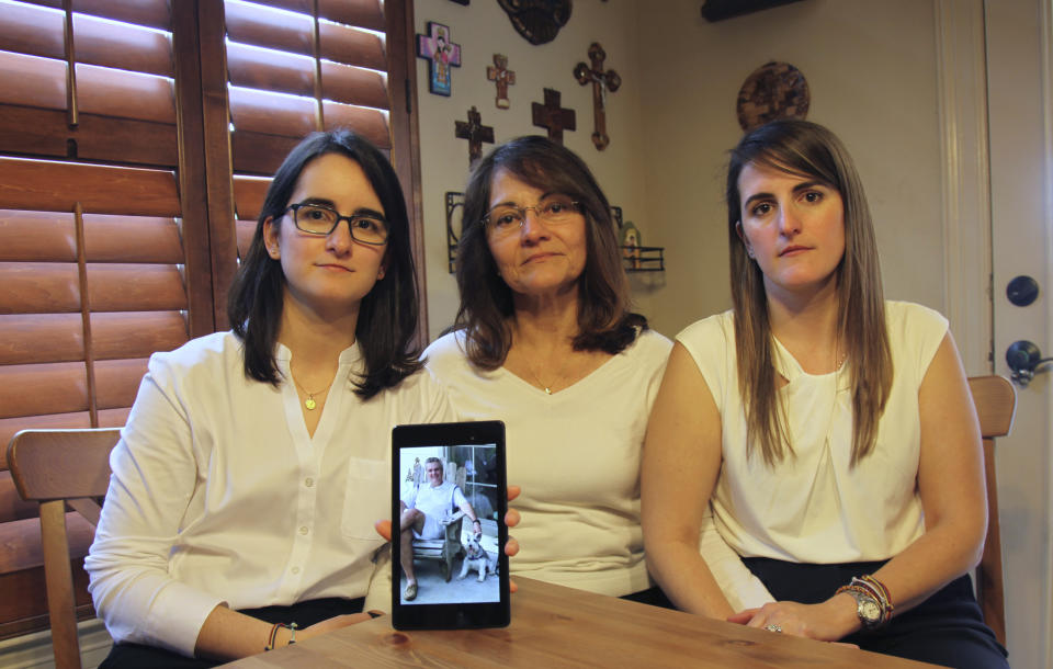 FILE - In this Feb. 15, 2019 file photo, Dennysse Vadell sits between her daughters Veronica, right, and Cristina holding a digital photograph of father and husband Tomeu who is currently jailed in Venezuela, in Katy, Texas. Tomeu Vadell, who is one of six U.S. oil executive jailed for three years in Venezuela, says in a letter from prison provided to The Associated Press on Tuesday, Nov. 24, 2020, that it’s especially painful to be separated during the Thanksgiving season from from his wife, three adult children and a newborn grandson he’s never held. (AP Photo/John L Mone, File)