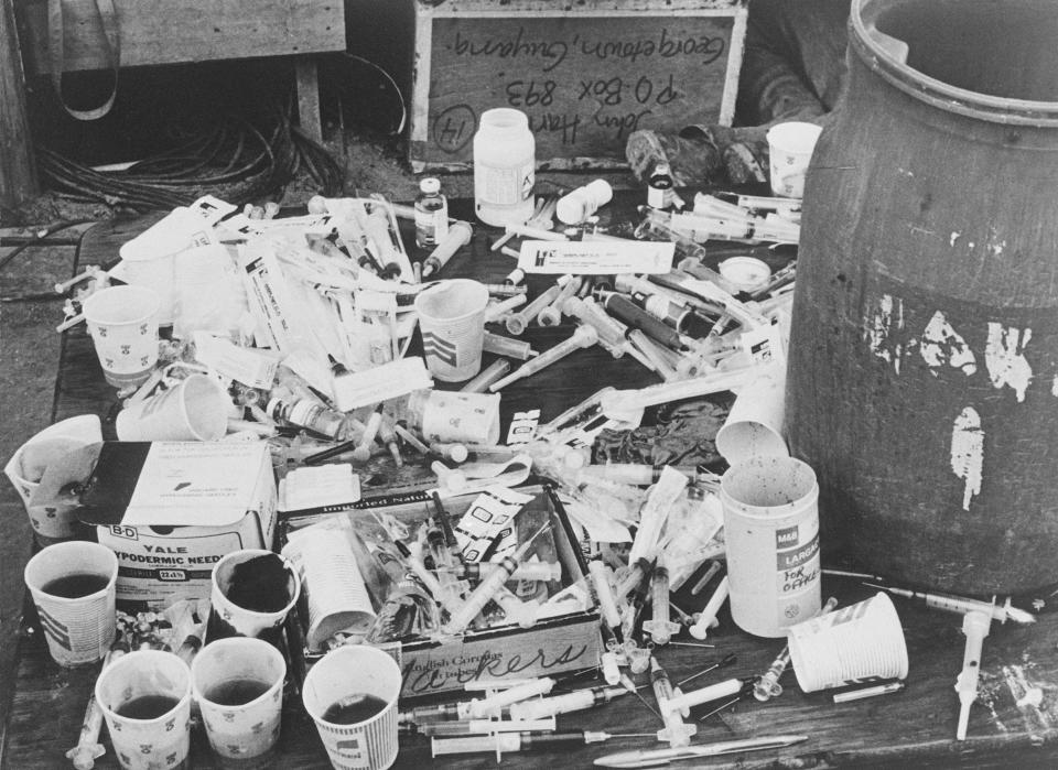 A pile of paper cups with cyanide-laced fruit punch, and a pile of hypodermic syringes, found at Jonestown by Guyanese officials.