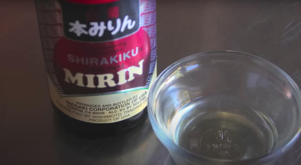 Bottle of Shirakiku Mirin next to a small, empty glass bowl on a table