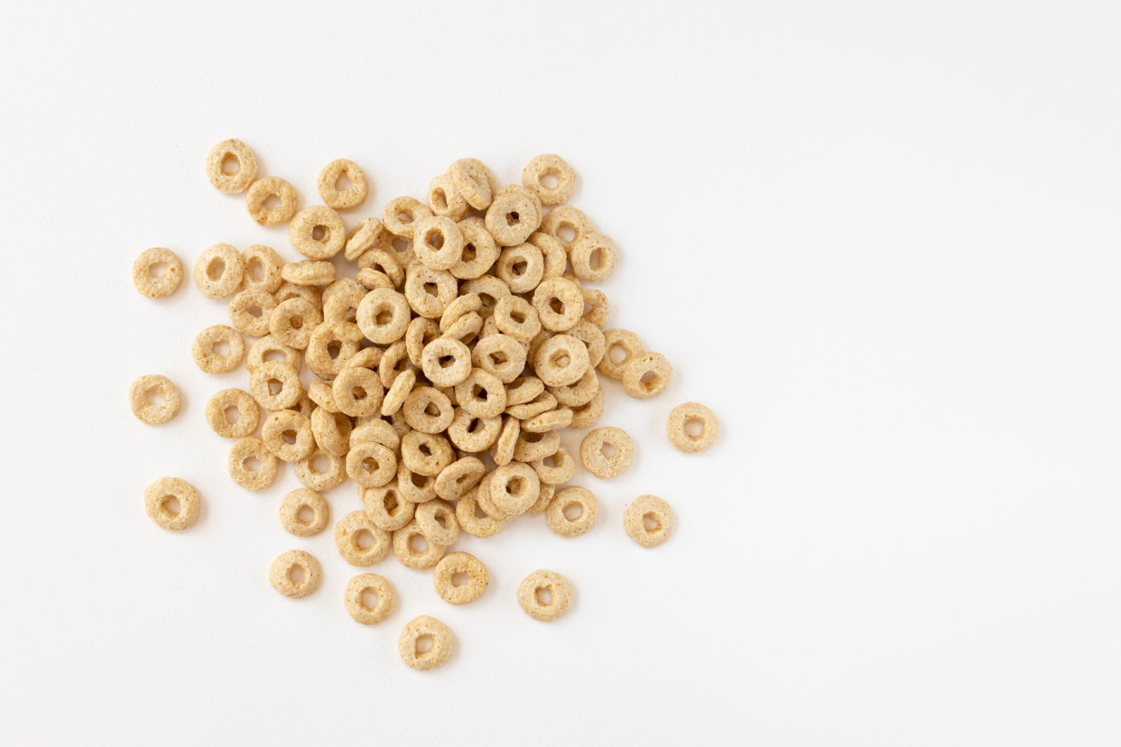 Top-view of a small pile of cheerios on the left-middle on a white background