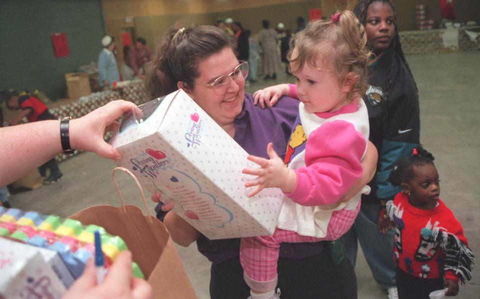 Linda Donovan is tickled with happiness as her daughter K.C., 2, receives a toy at the 19th annual J.P. Hall Sr. Children's Charities toy giveaway at the Clay County Agricultural Fairgrounds in 1998.